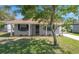 Inviting single-story home featuring lush lawn, landscaping, and a freshly painted facade at 2613 E 113Th Ave, Tampa, FL 33612