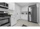 Well-lit kitchen with stainless steel appliances, white cabinets, and lots of countertop space at 2613 E 113Th Ave, Tampa, FL 33612