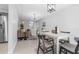 Open-concept living room and dining area featuring neutral paint, tile floors, and modern light fixtures at 2613 E 113Th Ave, Tampa, FL 33612