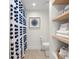 Clean bathroom with floating wood shelves, a patterned shower curtain, and neutral paint colors at 2620 Cove Cay Dr # 704, Clearwater, FL 33760