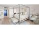 Beautiful bedroom featuring a four-poster bed, light wood flooring and an ensuite bathroom at 2620 Cove Cay Dr # 704, Clearwater, FL 33760
