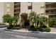Attractive entrance to a condo building featuring palm trees and manicured landscaping at 2620 Cove Cay Dr # 704, Clearwater, FL 33760