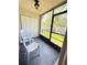 Enclosed balcony with two white chairs and view of the green backyard at 2625 State Road 590 # 913, Clearwater, FL 33759