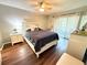 Bedroom with hardwood floors, white furnishings, and sliding doors to balcony at 2625 State Road 590 # 913, Clearwater, FL 33759