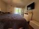Bedroom featuring sliding doors to balcony, television, and dresser at 2625 State Road 590 # 913, Clearwater, FL 33759