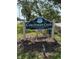 Sign for Coachman Creek Condominiums surrounded by green grass and landscaping at 2625 State Road 590 # 913, Clearwater, FL 33759