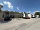 Condominium exterior showcasing ample parking and neutral color palette under a sunny blue sky with clouds at 2625 State Road 590 # 913, Clearwater, FL 33759