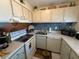 Functional kitchen showcasing white appliances, a decorative backsplash, and ample cabinet space at 2625 State Road 590 # 913, Clearwater, FL 33759