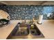 Close-up of the kitchen sink area featuring a stylish backsplash, countertop accessories and stainless steel faucet at 2625 State Road 590 # 913, Clearwater, FL 33759