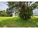Spacious front yard featuring lush green grass and mature trees surrounding the charming two-story home at 2807 57Th S St, Gulfport, FL 33707