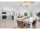Bright kitchen and dining area with modern appliances, stylish light green cabinets, and wood-look floors at 2807 57Th S St, Gulfport, FL 33707
