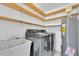 Efficient laundry room with modern washer and dryer and convenient overhead wood shelving for ample storage at 2807 57Th S St, Gulfport, FL 33707