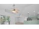 Open-concept interior featuring stylish ceiling fans, kitchen with light green cabinets, and sliding glass doors at 2807 57Th S St, Gulfport, FL 33707