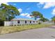 Eye-level street view of single story home with mature trees and a well-maintained front yard and white fence at 2907 W Tyson Ave, Tampa, FL 33611