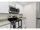 Modern kitchen with stainless steel microwave and oven, complemented by granite countertops at 2907 W Tyson Ave, Tampa, FL 33611