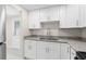 Well-lit kitchen featuring white cabinets, granite countertops, and a stainless steel sink at 2907 W Tyson Ave, Tampa, FL 33611