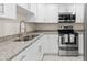 Bright kitchen featuring white cabinets, stainless steel appliances, and granite countertops at 2907 W Tyson Ave, Tampa, FL 33611