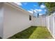 Side yard view showing a grassy area and a white privacy fence, enhancing outdoor living at 2907 W Tyson Ave, Tampa, FL 33611