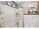 Modern bathroom featuring white subway tile, a glass enclosed shower, and a matching toilet, accented with artwork at 3112 W Wallcraft Ave, Tampa, FL 33611