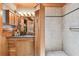 Bathroom vanity with custom natural wood cabinets and granite countertops paired with tiled glass enclosed shower at 3112 W Wallcraft Ave, Tampa, FL 33611