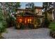 Eye-catching two-story home illuminated at night with stone driveway and tropical landscaping at 3112 W Wallcraft Ave, Tampa, FL 33611