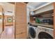 This laundry room features a washer, dryer, wooden cabinets, and wood floors at 3112 W Wallcraft Ave, Tampa, FL 33611
