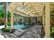 Backyard oasis showcasing a pool, covered patio, and a beautiful stone paver deck surrounded by lush landscaping at 3112 W Wallcraft Ave, Tampa, FL 33611