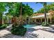 Picturesque backyard pool surrounded by lush landscaping, a covered patio, and a lovely stone paver deck at 3112 W Wallcraft Ave, Tampa, FL 33611