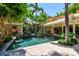 Beautiful pool surrounded by lush landscaping, a covered patio, and a stone paver deck, ideal for outdoor enjoyment at 3112 W Wallcraft Ave, Tampa, FL 33611