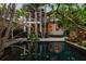 Gorgeous home reflected in the still water of the landscaped pool; surrounded by tropical foliage and trees at 3112 W Wallcraft Ave, Tampa, FL 33611