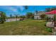 Waterfront backyard featuring a lush lawn, black fence, and palm trees at 31747 Loch Aline Dr, Wesley Chapel, FL 33545