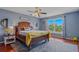 Bright bedroom featuring hardwood floors, a ceiling fan, and large window with views of the yard at 31747 Loch Aline Dr, Wesley Chapel, FL 33545