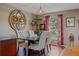 Charming dining room with elegant round mirror and decor with wooden floors, perfect for intimate gatherings at 31747 Loch Aline Dr, Wesley Chapel, FL 33545