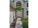 Inviting front entrance with a decorative pergola and lush hanging plants creating a warm and welcoming ambiance at 31747 Loch Aline Dr, Wesley Chapel, FL 33545