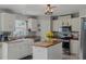 Bright kitchen features white cabinets, farmhouse sink, butcher block island, and stainless steel appliances at 31747 Loch Aline Dr, Wesley Chapel, FL 33545