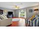 Cozy living room with hardwood floors, ceiling fan, and large window overlooking backyard at 31747 Loch Aline Dr, Wesley Chapel, FL 33545