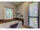 Charming bathroom with a soaking tub, stained glass window, and decorative tile surround at 3410 Briarwood Ln, Safety Harbor, FL 34695
