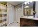 Cozy bathroom with a dark wood vanity, mirror, wood look flooring, and door to exterior at 3410 Briarwood Ln, Safety Harbor, FL 34695