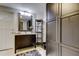 Bathroom featuring a vanity, large mirror, custom shelving, and a dark wood linen closet at 3410 Briarwood Ln, Safety Harbor, FL 34695
