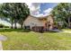 Side view of home with lush green lawn and exterior details with a wooden fence at 3410 Briarwood Ln, Safety Harbor, FL 34695