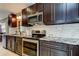 Modern kitchen with stainless steel appliances, dark cabinets, and a stylish backsplash at 3410 Briarwood Ln, Safety Harbor, FL 34695
