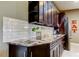 Close-up of kitchen with dark cabinetry, sleek countertops, and modern backsplash at 3410 Briarwood Ln, Safety Harbor, FL 34695