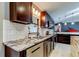 Modern kitchen features stainless steel dishwasher, sink, and dark cabinets with granite countertops at 3410 Briarwood Ln, Safety Harbor, FL 34695