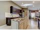 Spacious kitchen with center island, dark cabinets, granite countertops, and stainless refrigerator at 3410 Briarwood Ln, Safety Harbor, FL 34695