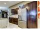Bright kitchen with dark wood cabinetry, stainless steel refrigerator, and stone countertops at 3410 Briarwood Ln, Safety Harbor, FL 34695