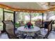 Enclosed patio with outdoor seating, grill, and view of the lush backyard at 3410 Briarwood Ln, Safety Harbor, FL 34695