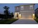 Inviting two-story home featuring a two-car garage and well-maintained landscape lighting at 3446 Suncoast Plains Dr, Odessa, FL 33556