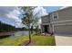Charming home with a well-manicured lawn, a pond, and beautiful landscaping at 3446 Suncoast Plains Dr, Odessa, FL 33556