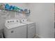 Functional laundry room with a washer, dryer, and shelving for storage at 3446 Suncoast Plains Dr, Odessa, FL 33556