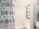 Well-lit tub and shower with patterned blue shower curtain and window at 3455 Countryside Blvd # 101, Clearwater, FL 33761